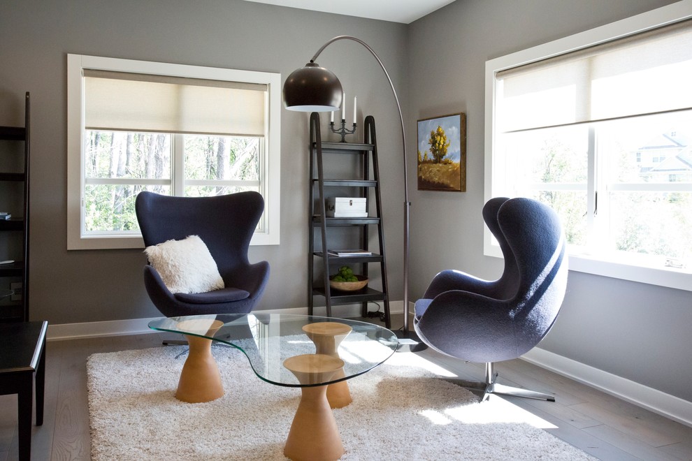 Ejemplo de sala de estar con biblioteca campestre con paredes grises, suelo de madera en tonos medios y suelo marrón