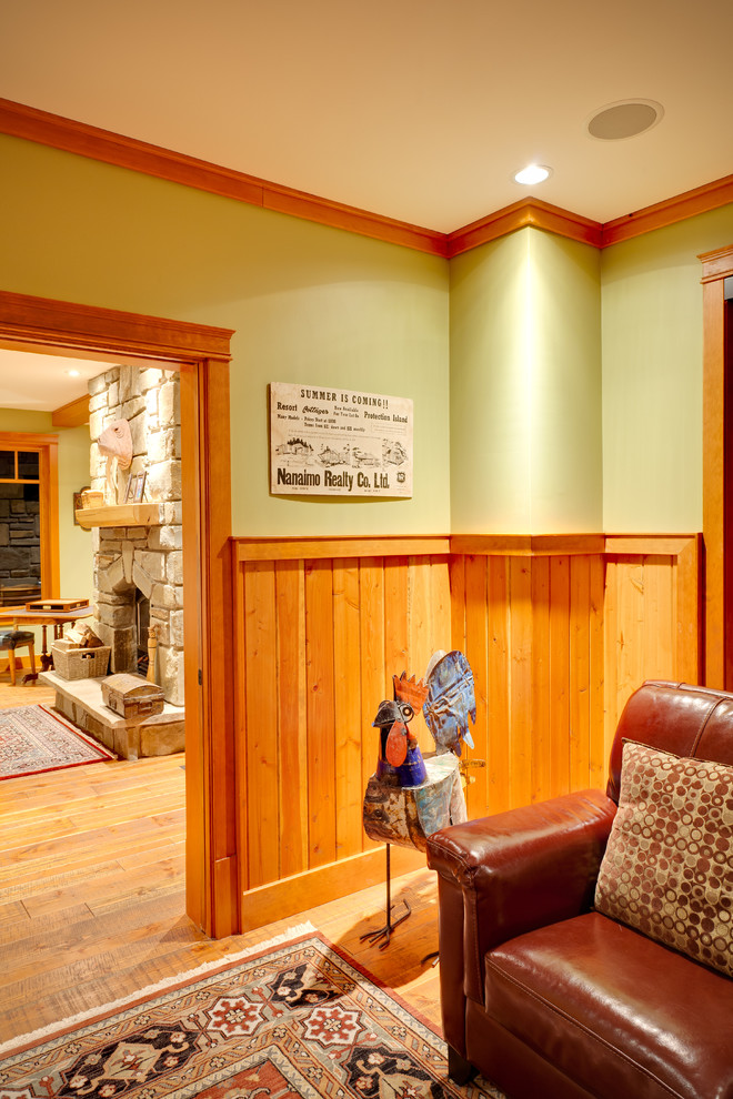 Imagen de sala de estar clásica con paredes verdes, suelo de madera clara, pared multimedia y suelo naranja