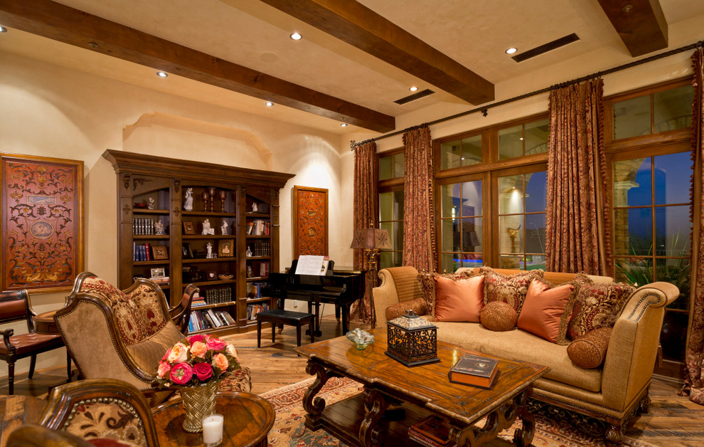 Exemple d'une très grande salle de séjour sud-ouest américain ouverte avec un mur beige, un sol en bois brun, une salle de musique, une cheminée standard, un manteau de cheminée en pierre et aucun téléviseur.