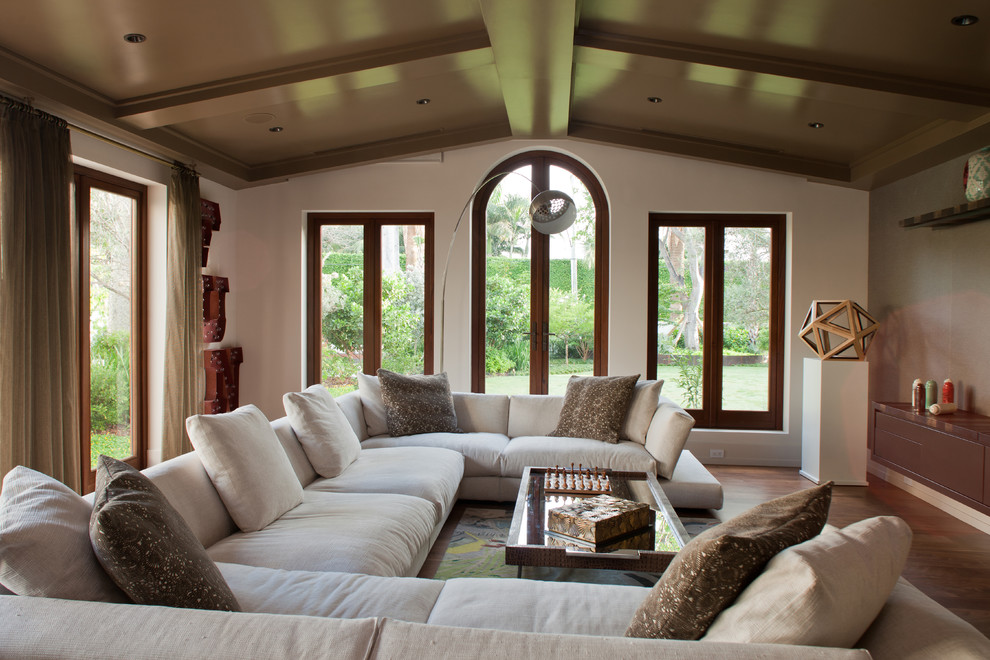 Exemple d'une salle de séjour tendance avec un mur beige et un sol en bois brun.
