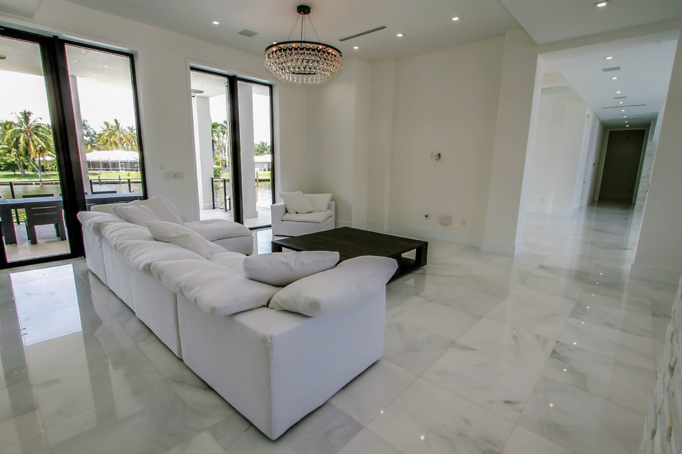 Ejemplo de sala de estar abierta moderna grande sin chimenea con paredes blancas, suelo de mármol y suelo blanco
