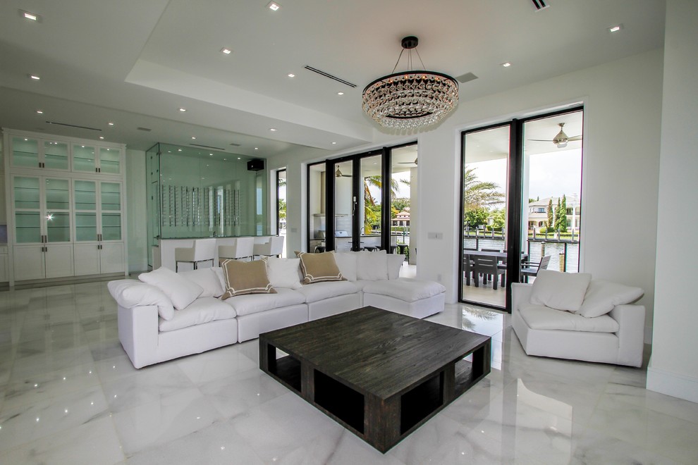 Example of a large minimalist open concept marble floor and white floor family room design in Miami with white walls and no fireplace