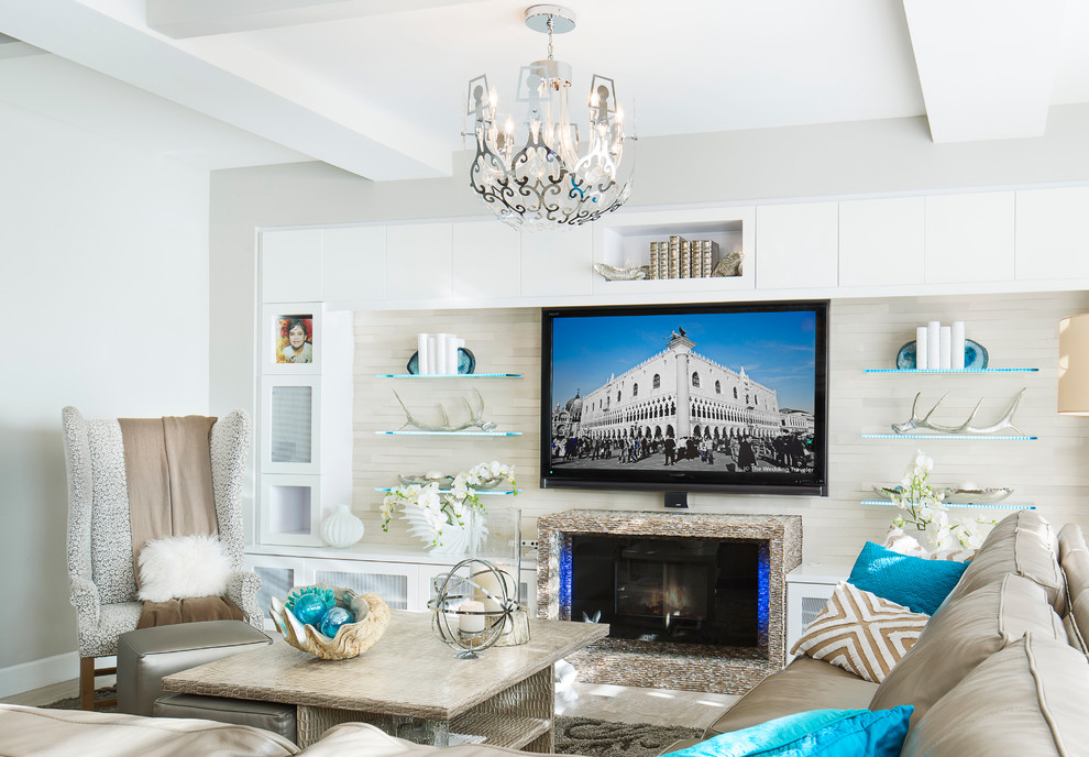 На фото: изолированная гостиная комната среднего размера в стиле неоклассика (современная классика) с белыми стенами, стандартным камином, фасадом камина из камня и телевизором на стене с