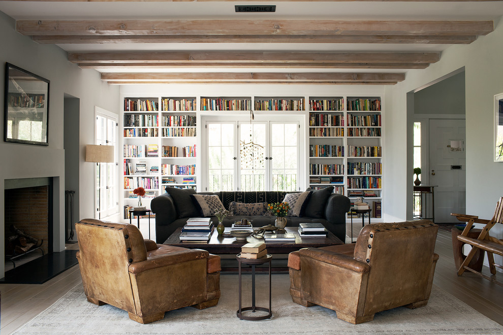 Esempio di un soggiorno contemporaneo chiuso con libreria, pareti grigie, parquet chiaro e camino classico