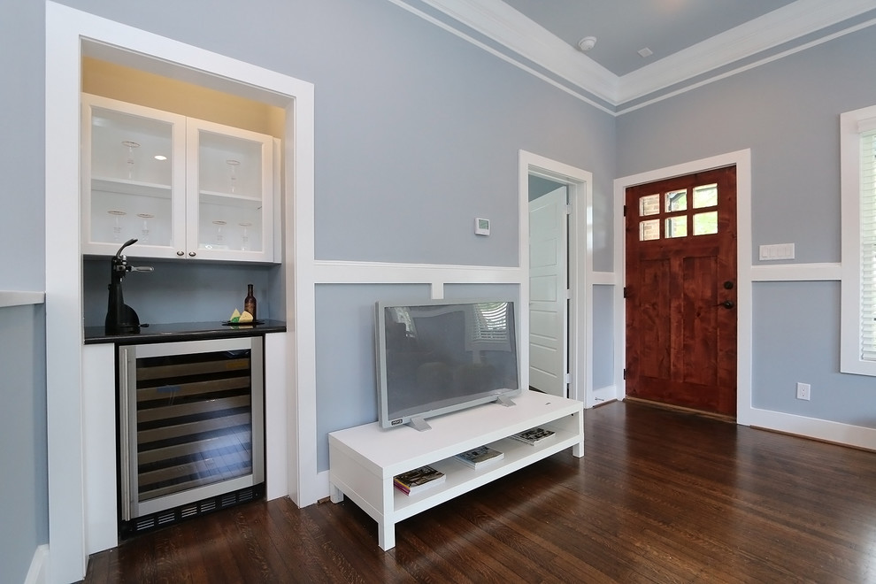На фото: открытая гостиная комната среднего размера в стиле кантри с домашним баром, синими стенами, темным паркетным полом и отдельно стоящим телевизором без камина с
