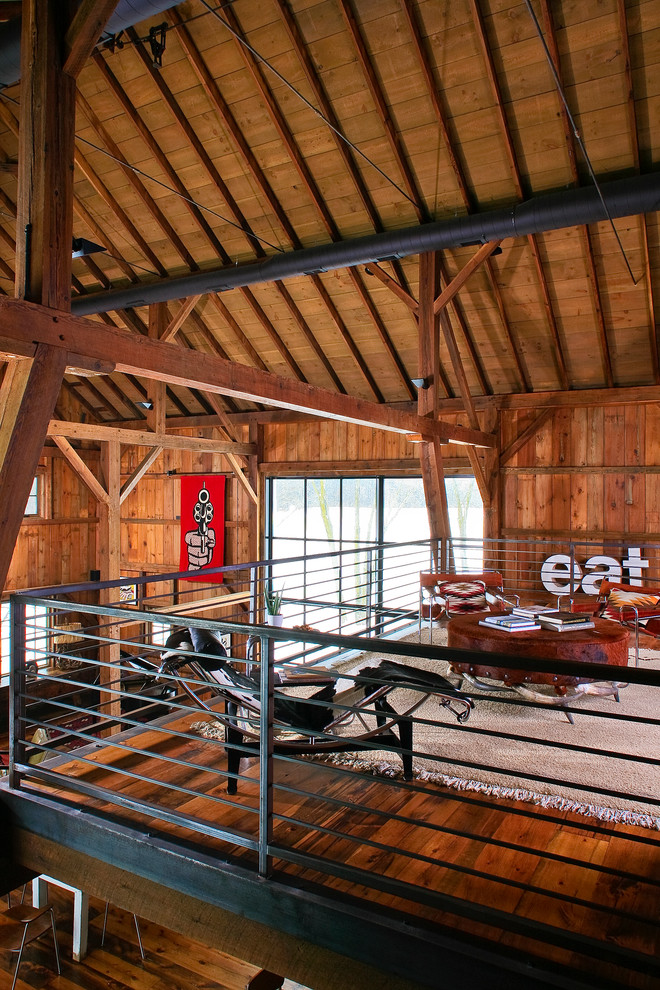 Ispirazione per un soggiorno country stile loft con pavimento in legno massello medio e tappeto