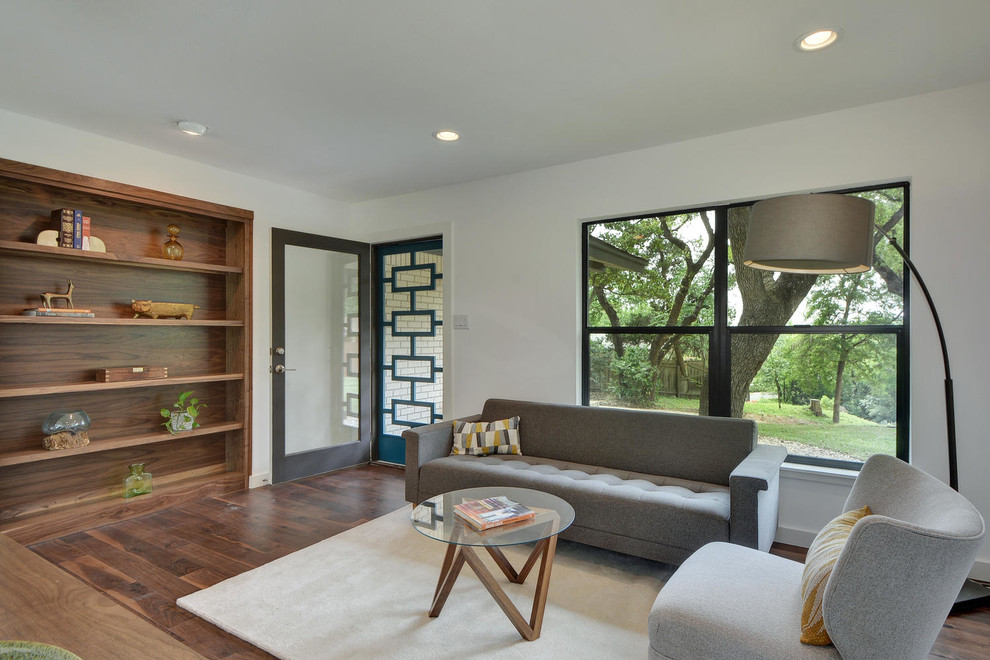 Inspiration for a mid-sized modern enclosed dark wood floor family room library remodel in Austin with no fireplace, a wall-mounted tv and white walls