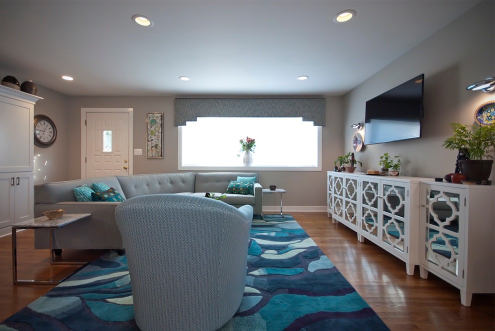 Foto di un soggiorno minimalista di medie dimensioni e aperto con pareti grigie, pavimento in legno massello medio, nessun camino e TV a parete