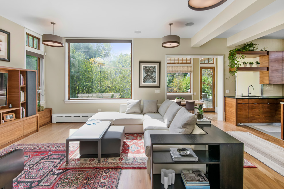 Foto de sala de estar abierta actual con suelo de madera en tonos medios y pared multimedia