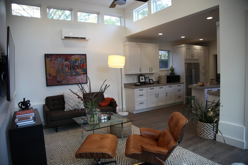 Esempio di un piccolo soggiorno moderno aperto con pareti bianche, pavimento in legno massello medio, TV a parete e pavimento marrone