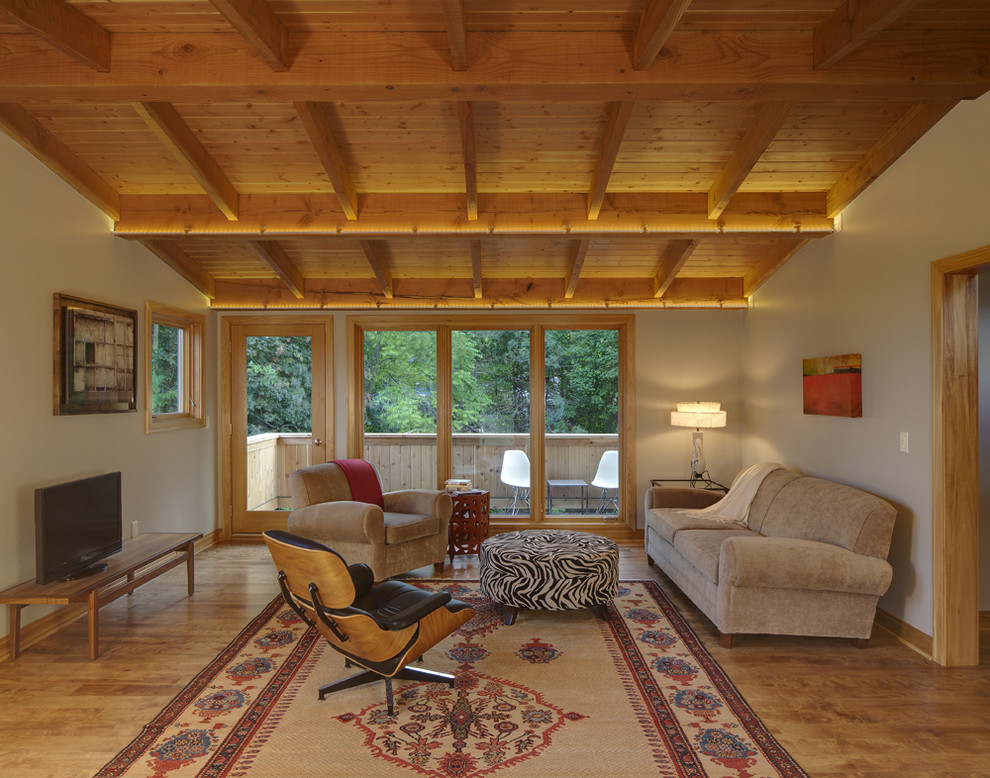 Foto di un grande soggiorno minimalista aperto con pareti grigie, pavimento in legno massello medio e TV a parete