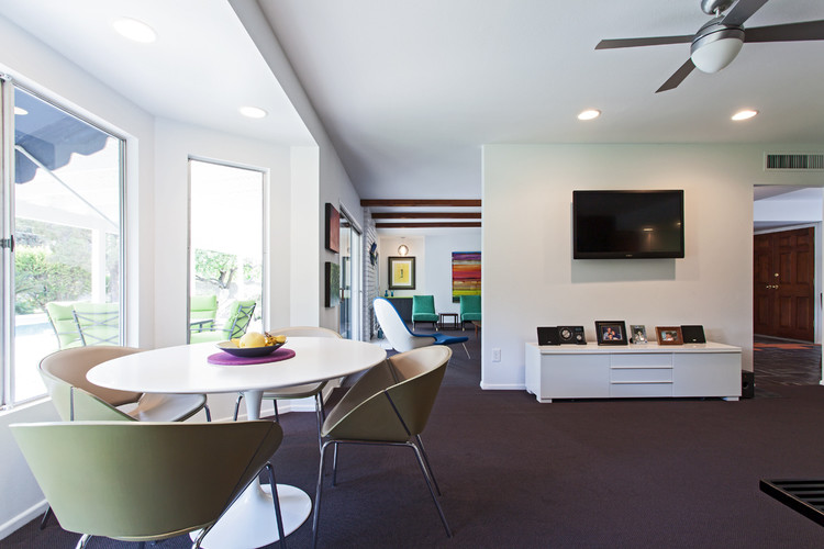 Diseño de sala de estar abierta retro sin chimenea con paredes blancas, moqueta y televisor colgado en la pared