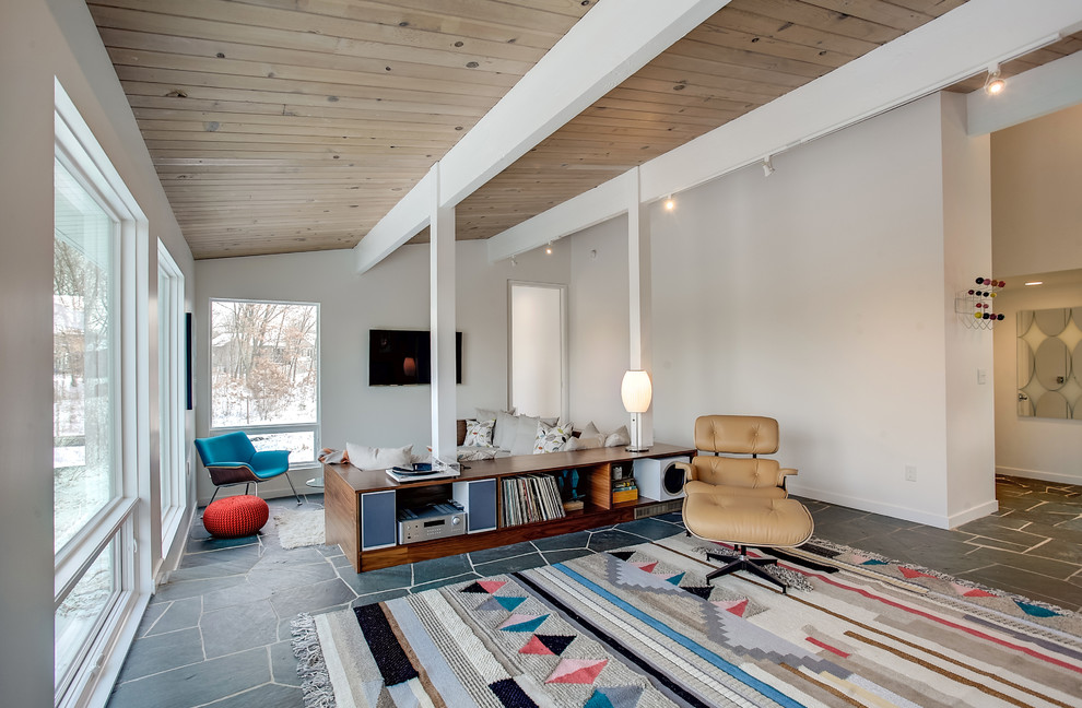 Immagine di un soggiorno moderno di medie dimensioni e aperto con pareti bianche, pavimento in ardesia, TV a parete, nessun camino e pavimento grigio
