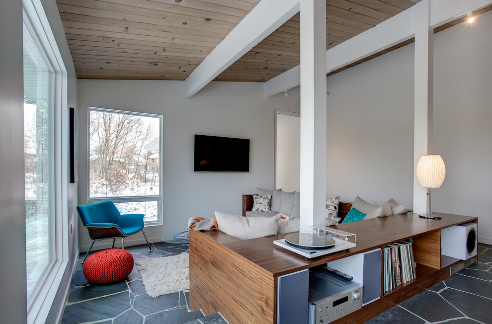 Medium sized midcentury open plan games room in Grand Rapids with white walls, slate flooring, a wall mounted tv, no fireplace and grey floors.