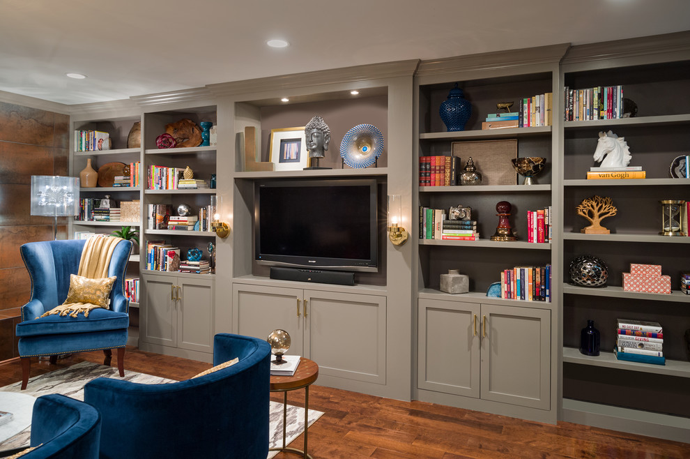 Ejemplo de sala de estar con biblioteca vintage de tamaño medio con paredes grises, suelo de madera en tonos medios y pared multimedia