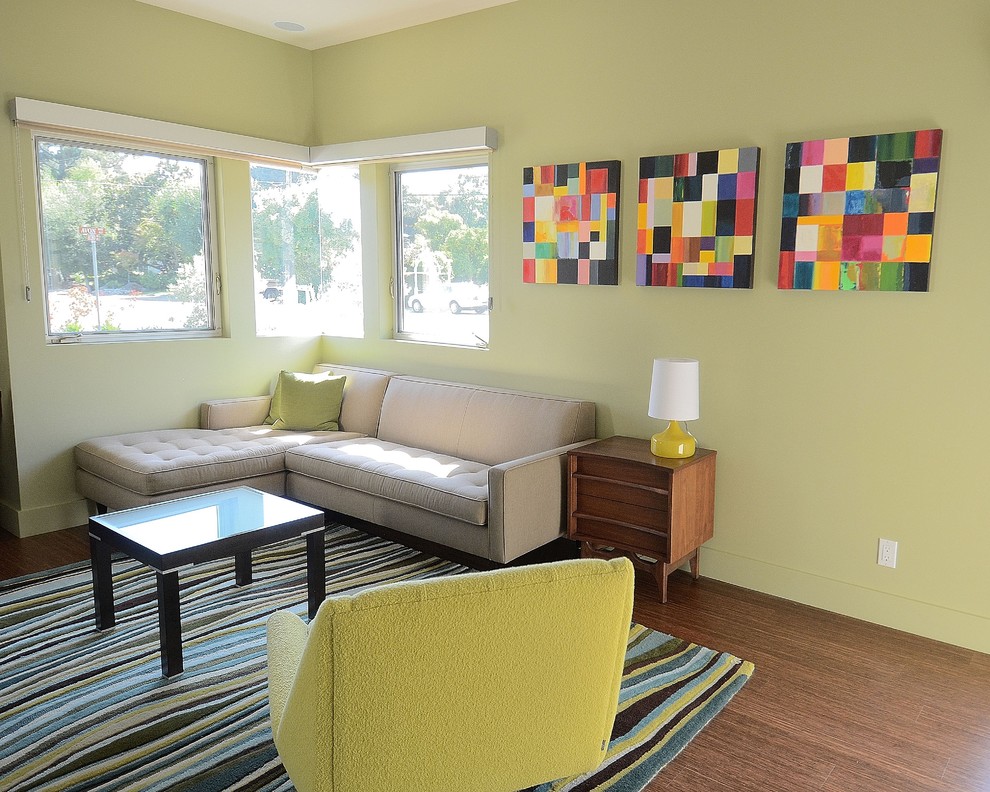 На фото: изолированная гостиная комната среднего размера в стиле ретро с зелеными стенами, темным паркетным полом и коричневым полом без камина, телевизора
