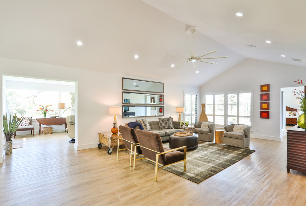 Großes, Offenes Retro Wohnzimmer ohne Kamin mit weißer Wandfarbe, hellem Holzboden, freistehendem TV und beigem Boden in Austin