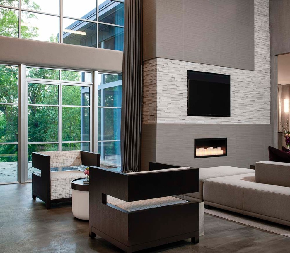 Inspiration for an expansive midcentury open plan games room in Detroit with grey walls, concrete flooring, a corner fireplace, a tiled fireplace surround, a built-in media unit and grey floors.