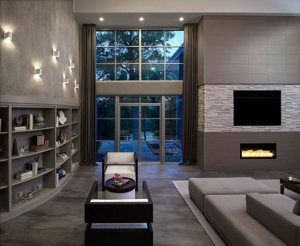 This is an example of an expansive midcentury open plan games room in Detroit with grey walls, concrete flooring, a corner fireplace, a tiled fireplace surround, a built-in media unit and grey floors.