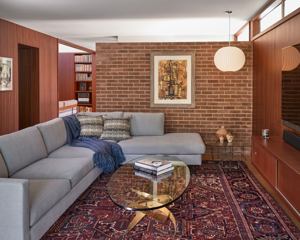 Diseño de sala de estar abierta retro de tamaño medio sin chimenea con paredes marrones, suelo de corcho, televisor colgado en la pared, suelo marrón, ladrillo y madera