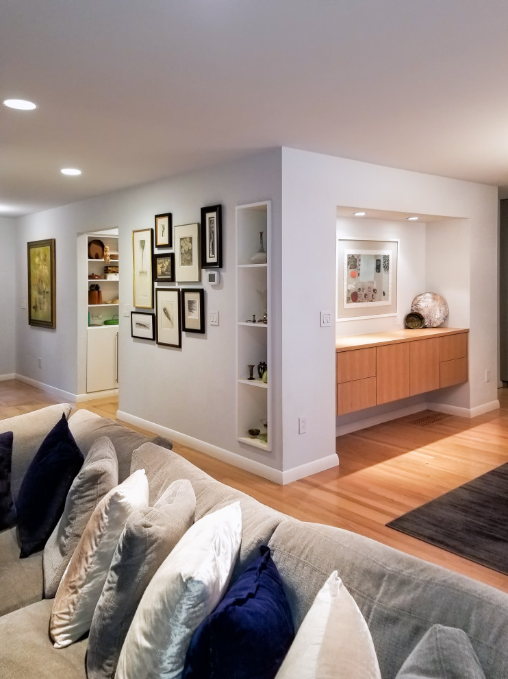Großes, Offenes Modernes Wohnzimmer mit grauer Wandfarbe, hellem Holzboden, Kamin, gefliester Kaminumrandung, TV-Wand und blauem Boden in Portland