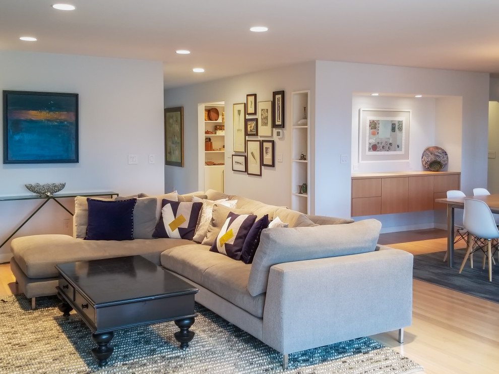 Источник вдохновения для домашнего уюта: большая открытая гостиная комната в современном стиле с серыми стенами, светлым паркетным полом, стандартным камином, фасадом камина из плитки, телевизором на стене и синим полом