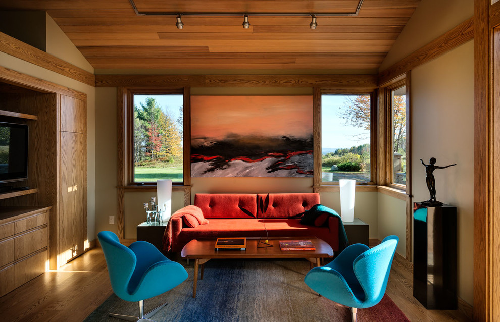 Imagen de sala de estar retro con paredes beige, suelo de madera en tonos medios y pared multimedia