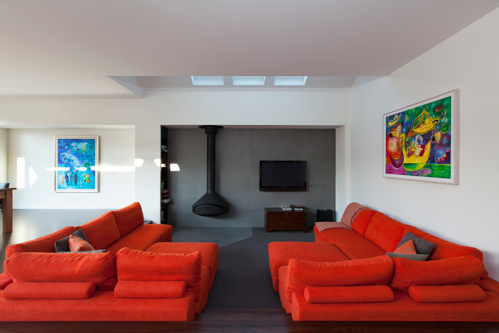 Idee per un soggiorno design aperto con pareti grigie e TV a parete