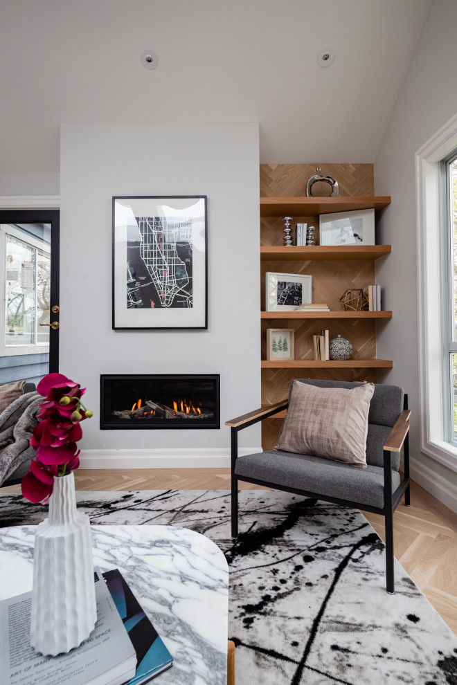 Mittelgroßes, Fernseherloses, Offenes Klassisches Wohnzimmer mit grauer Wandfarbe, hellem Holzboden, Kamin, verputzter Kaminumrandung und braunem Boden in Vancouver