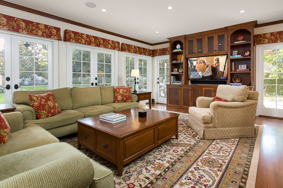 Immagine di un soggiorno tradizionale chiuso con pareti bianche, pavimento in legno massello medio e TV autoportante