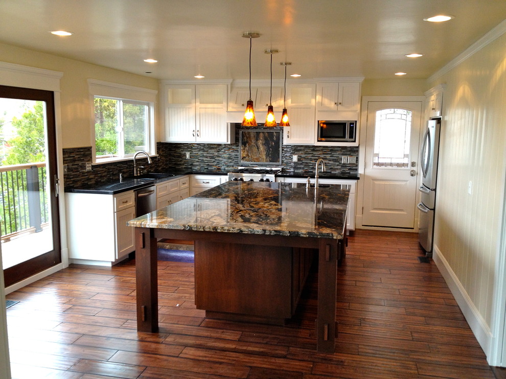 Cette photo montre une cuisine chic de taille moyenne avec un sol en bois brun et un sol marron.