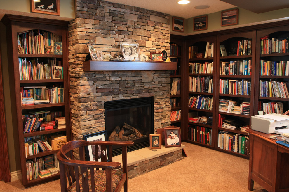 Family room library - mid-sized traditional enclosed carpeted family room library idea in Edmonton with green walls, a standard fireplace and a stone fireplace