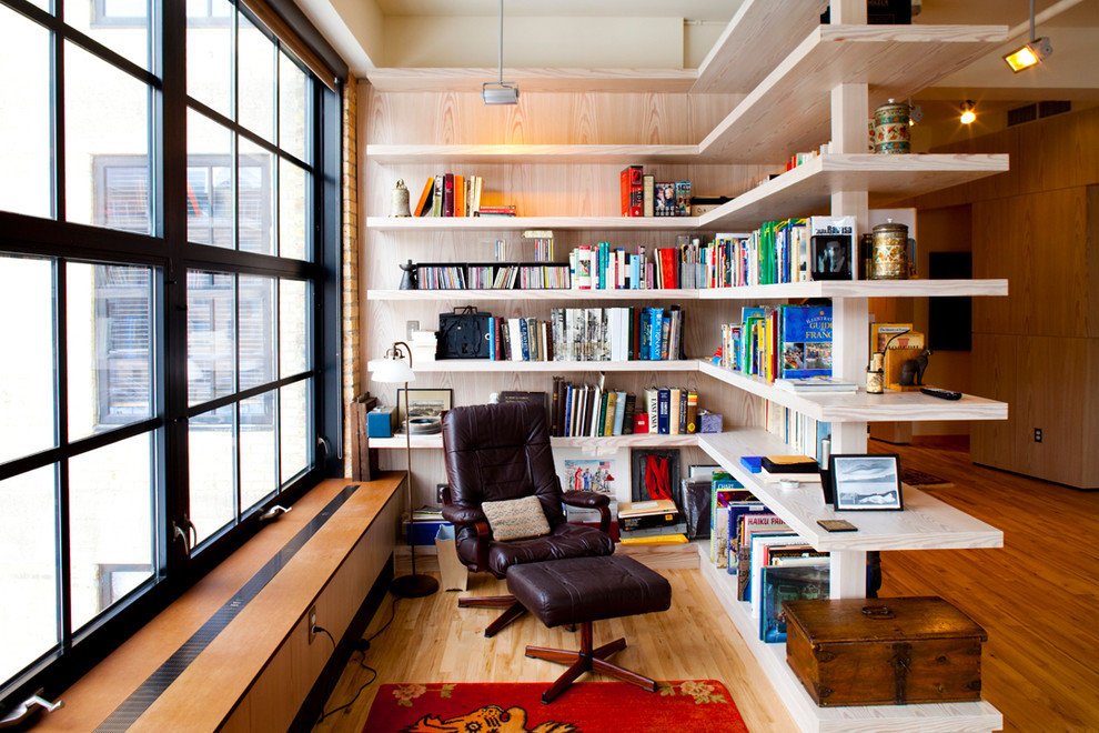 Idee per un soggiorno minimal con pavimento in legno massello medio e libreria