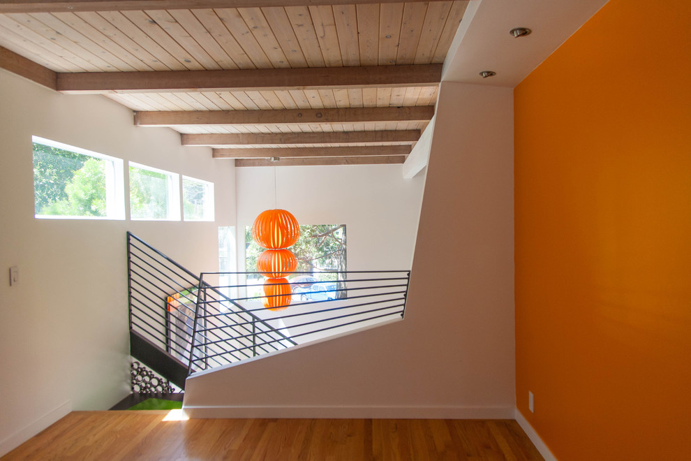 Mittelgroßes, Fernseherloses, Offenes Modernes Wohnzimmer ohne Kamin mit oranger Wandfarbe und hellem Holzboden in San Francisco