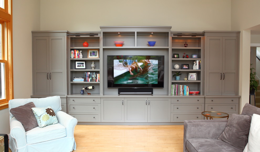 Esempio di un ampio soggiorno contemporaneo con pareti beige, parquet chiaro e TV a parete