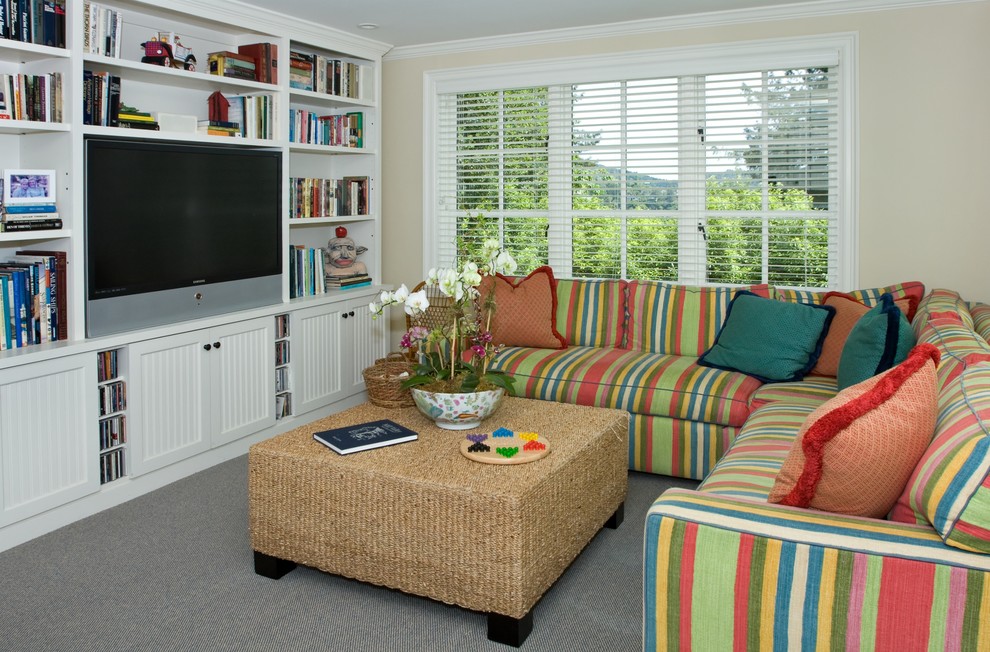 Cette image montre une salle de séjour traditionnelle de taille moyenne avec un mur beige, moquette, un téléviseur encastré et un sol gris.