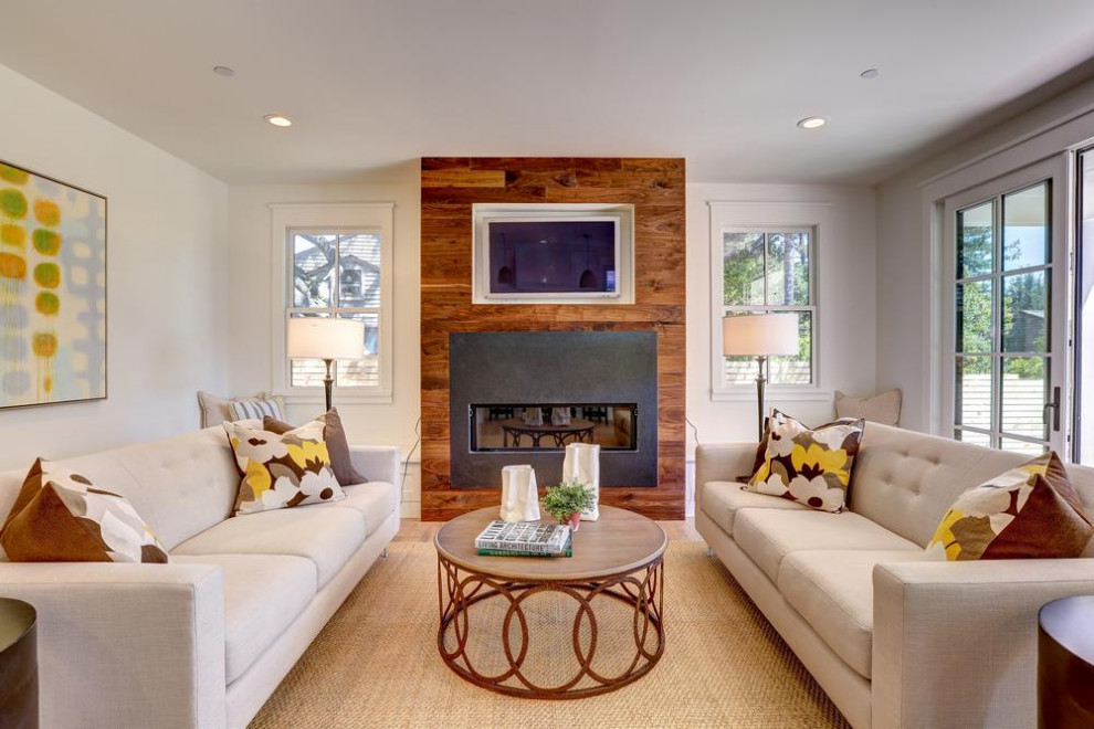 Inspiration for a mid-sized country open concept medium tone wood floor and brown floor family room remodel in San Francisco with white walls, a standard fireplace and a media wall