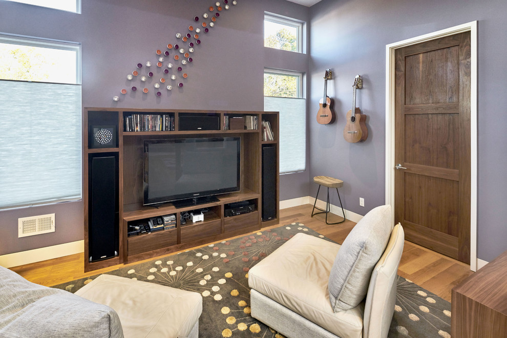 Foto di un soggiorno minimal di medie dimensioni e chiuso con pareti viola, pavimento in legno massello medio, nessun camino e parete attrezzata