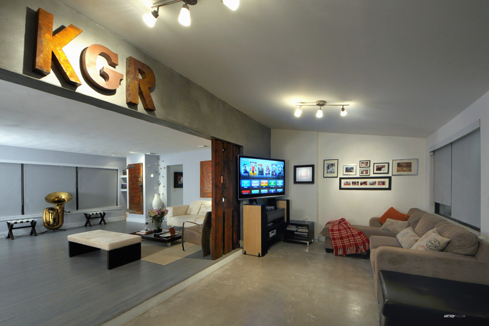 Exempel på ett mellanstort modernt allrum med öppen planlösning, med ett musikrum, grå väggar, betonggolv och en väggmonterad TV
