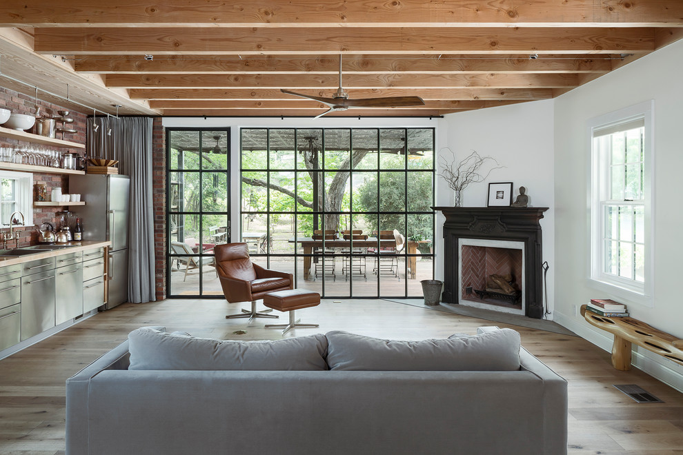 Country Wohnzimmer mit Hausbar, weißer Wandfarbe, hellem Holzboden, Eckkamin und beigem Boden in Austin