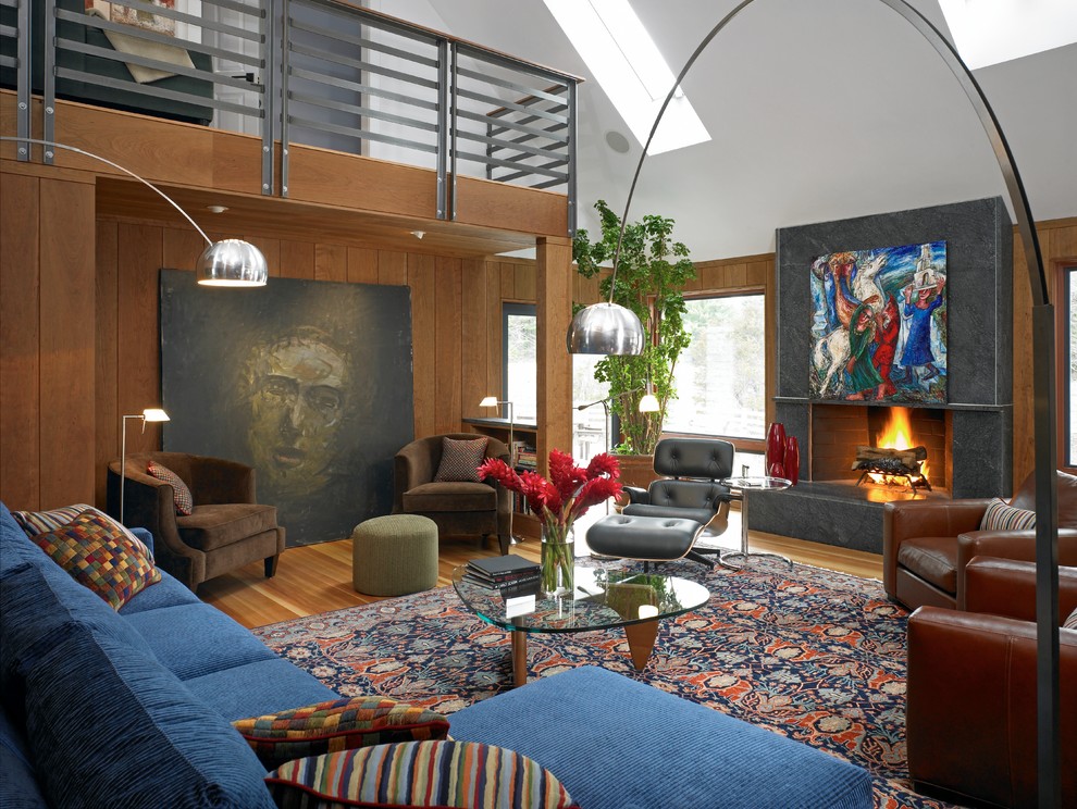 Immagine di un soggiorno contemporaneo aperto con pareti marroni, pavimento in legno massello medio e camino classico