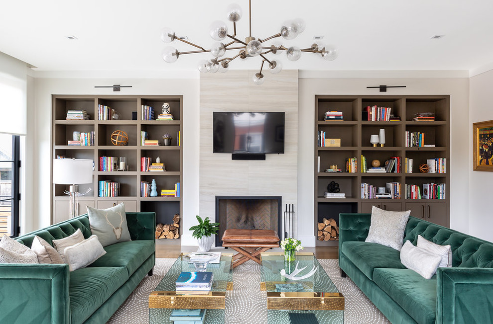 Esempio di un soggiorno design con libreria, pareti beige, camino classico, TV a parete, cornice del camino piastrellata e tappeto