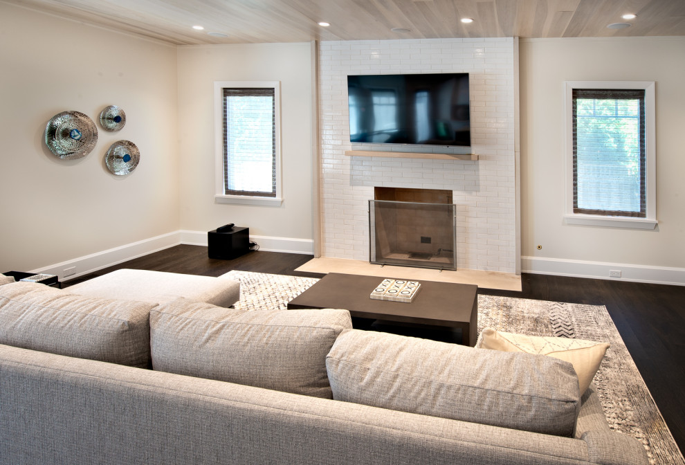 Photo of a contemporary open plan games room in Chicago with a reading nook, grey walls, a standard fireplace, a tiled fireplace surround, a wall mounted tv and a wood ceiling.