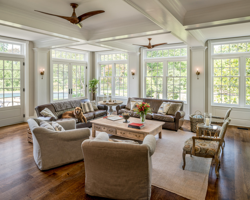 Ejemplo de sala de estar abierta de estilo de casa de campo grande con paredes beige, suelo marrón y suelo de madera oscura