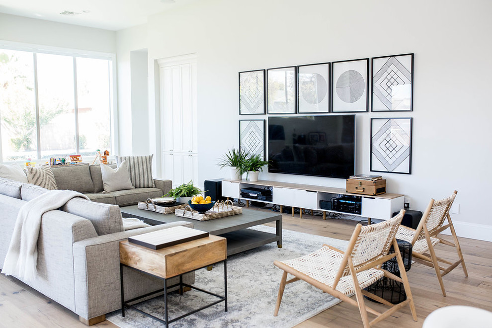 Стильный дизайн: большая открытая гостиная комната в стиле фьюжн с белыми стенами и телевизором на стене - последний тренд