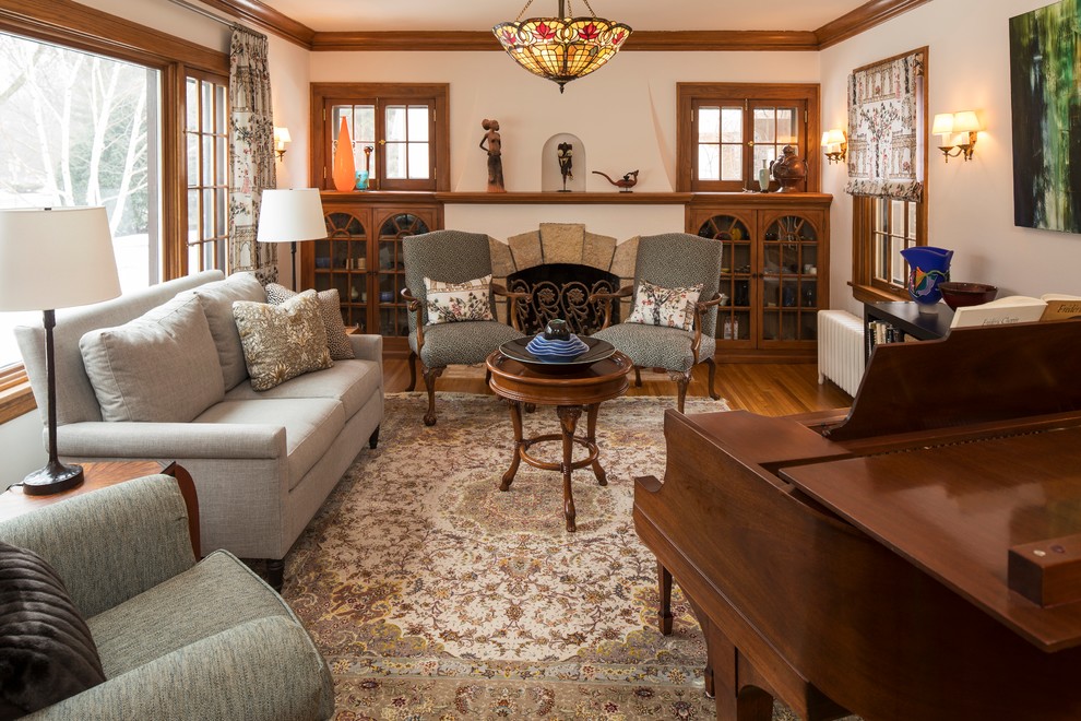 Foto de sala de estar con rincón musical clásica con paredes beige, suelo de madera en tonos medios, todas las chimeneas y marco de chimenea de piedra
