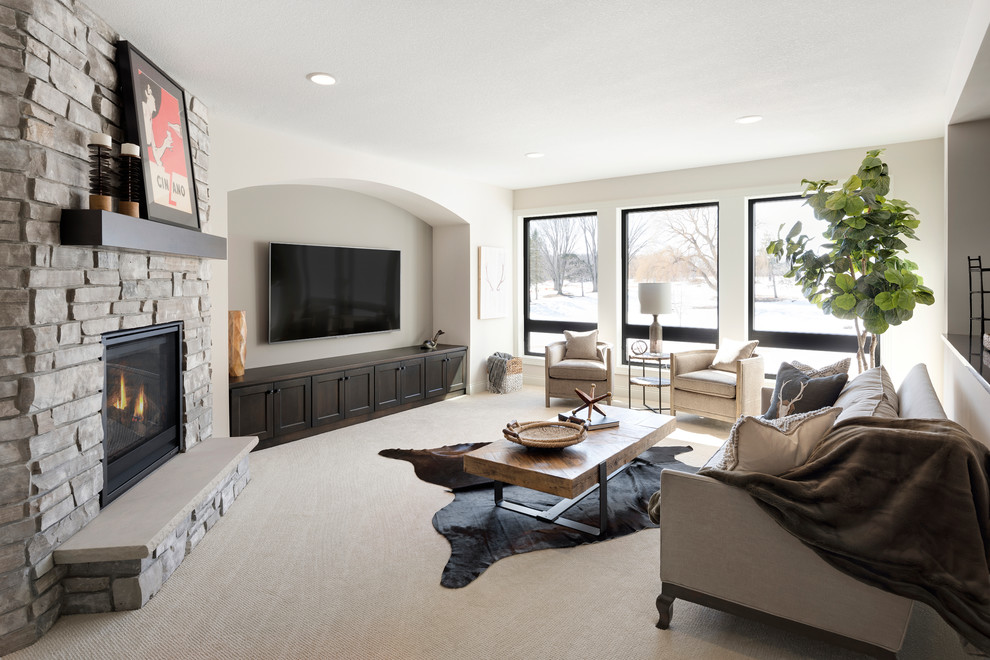 Modelo de sala de estar clásica renovada con moqueta, chimenea de esquina, marco de chimenea de piedra, televisor colgado en la pared y suelo beige