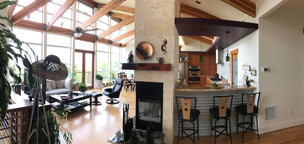 Large trendy open concept light wood floor and beige floor family room photo in Austin with beige walls, a standard fireplace and a stone fireplace