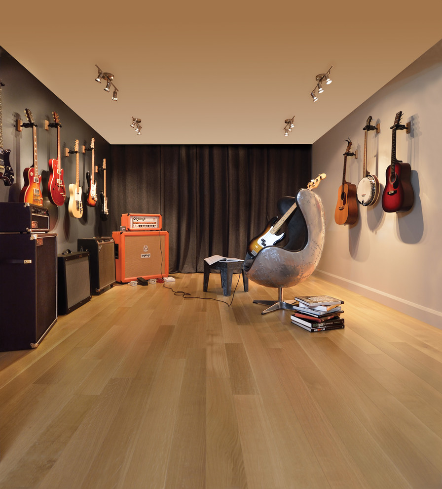 Inspiration for a medium sized modern open plan games room in New York with a music area, light hardwood flooring and grey walls.