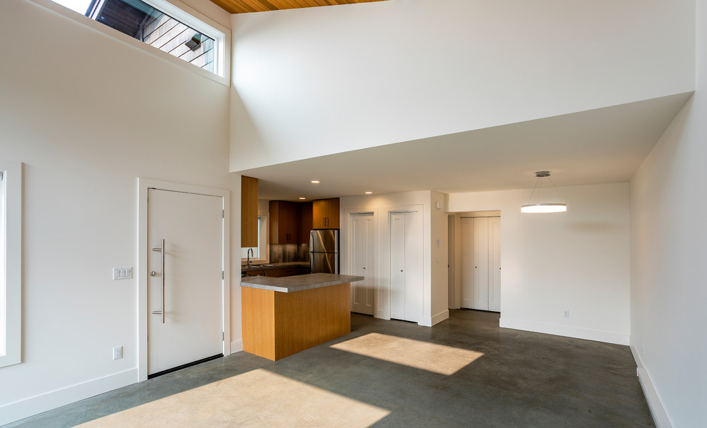 На фото: маленькая открытая гостиная комната в стиле модернизм с белыми стенами, бетонным полом, телевизором в углу и серым полом для на участке и в саду